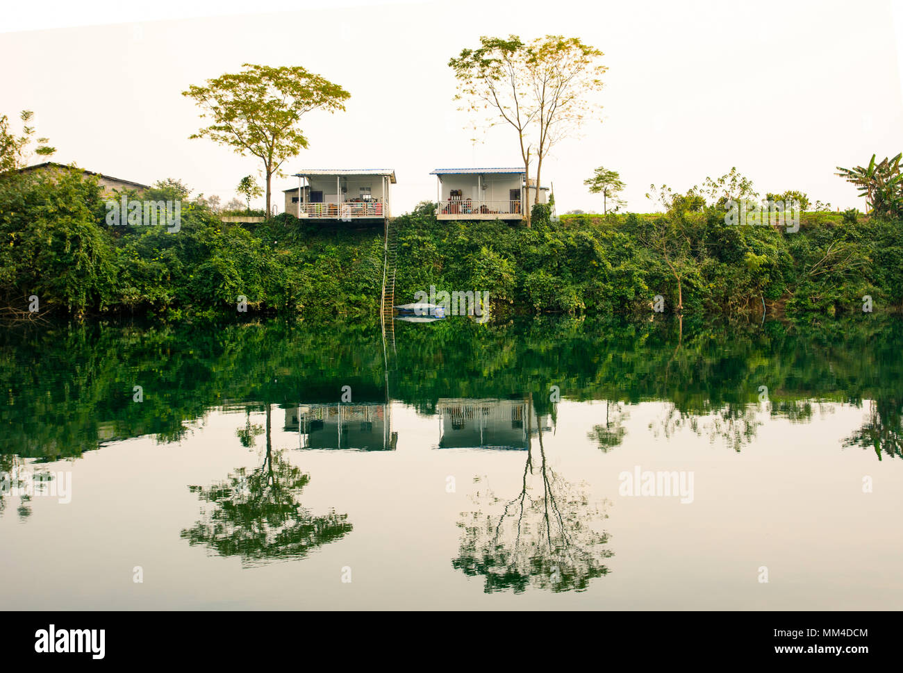 Parfait reflet des maisons dans l'lakle au coucher du soleil dans le Guangxi, Chine Banque D'Images