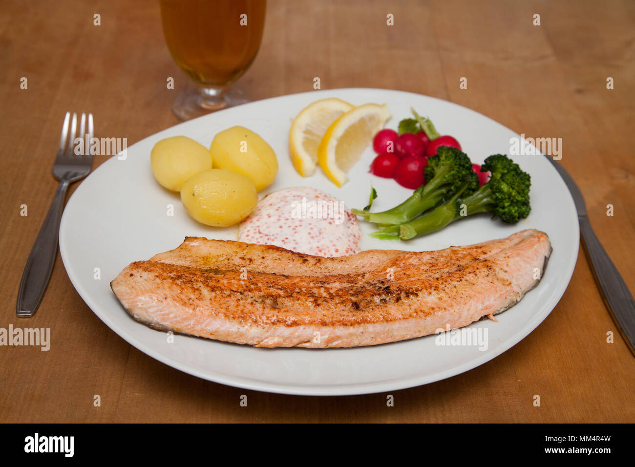 Fichier de la truite sur une assiette avec des pommes de terre et la sauce Banque D'Images