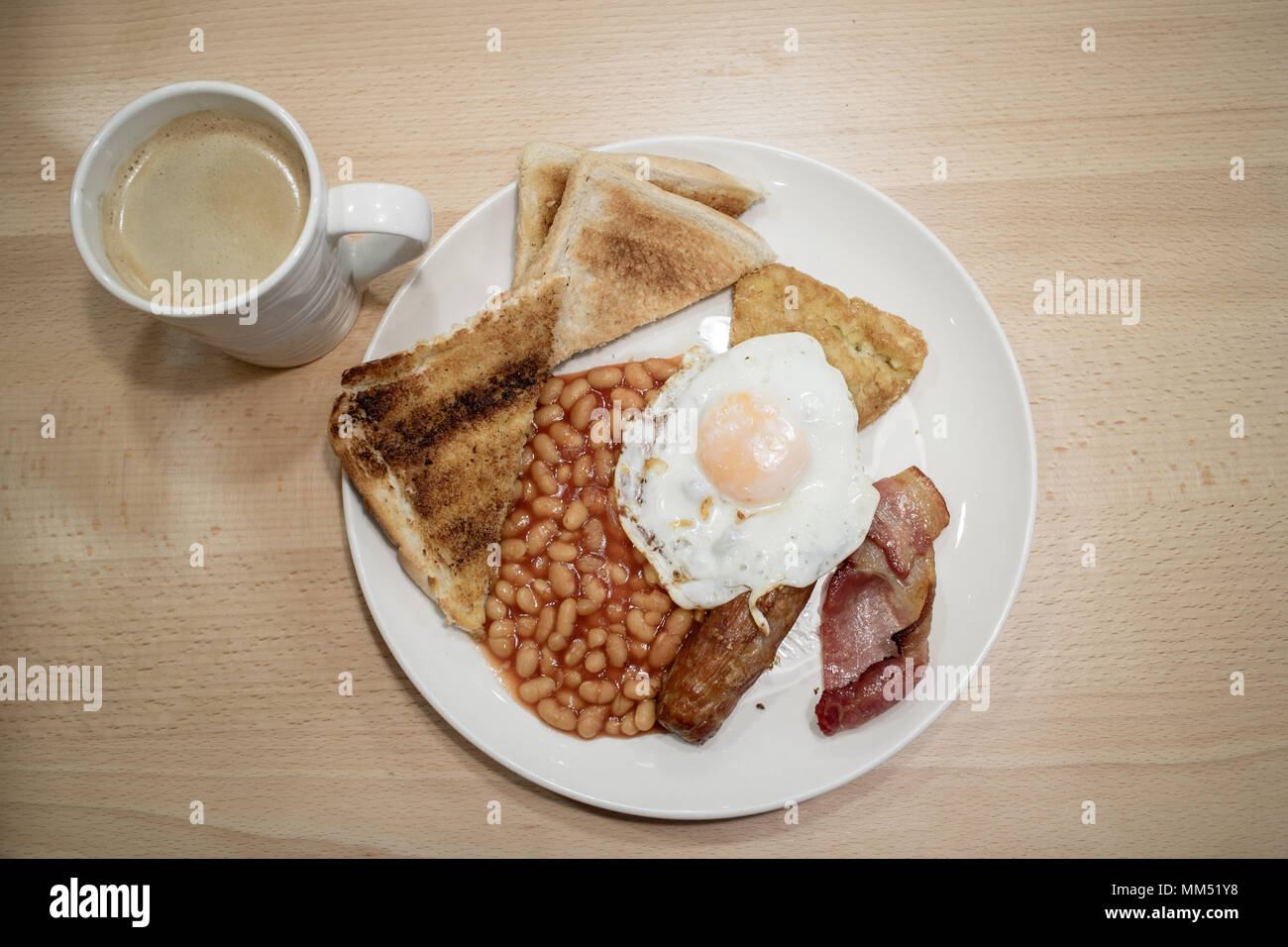 Un petit-déjeuner anglais complet avec un café noir sur une table de café Banque D'Images