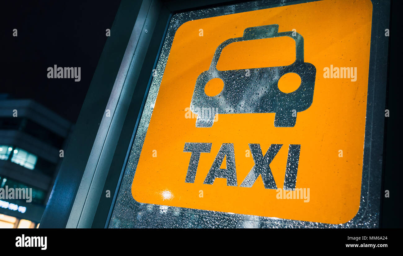Arrêt de taxi. Panneau jaune sur verre humide à rainy night Banque D'Images