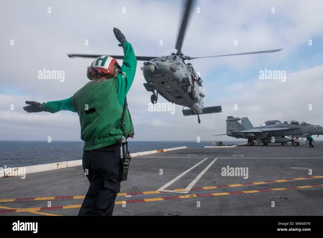 170907-N-ZO915-269 OCÉAN PACIFIQUE (sept. 7, 2017) l'Aviation Aviateur-électricien Angelique Primrose, affecté à la "mer des Chargers hélicoptère de combat de l'escadron (HSC) 14, dirige un Sea Hawk MH-60S'hélicoptère sur le pont d'envol du porte-avions USS JOHN C. STENNIS (CVN 74) lors des qualifications de l'opérateur. John C. Stennis est en cours la réalisation des qualifications et de la formation de l'opérateur pour de futures opérations après avoir terminé d'envol de la certification. (U.S. Photo par marine Spécialiste de la communication de masse 2e classe Jackson G. Brown/libérés) Banque D'Images