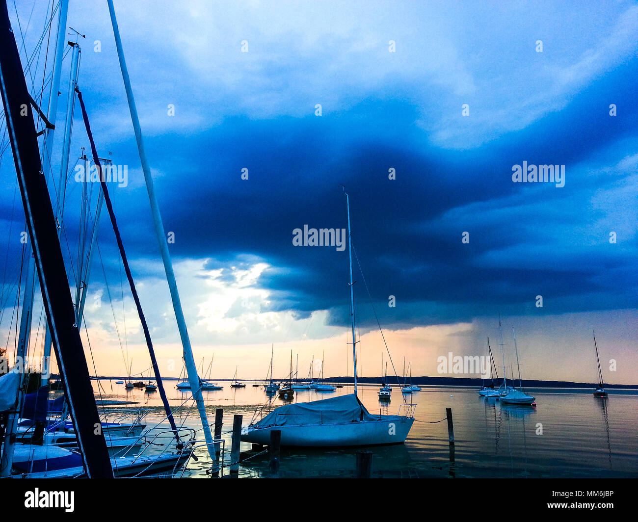 Bateaux à voile sur un lac avec des nuages sombres à venir Banque D'Images