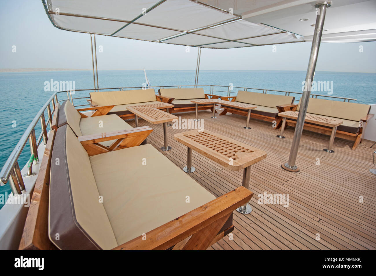 Pont arrière d'un grand yacht de luxe avec des chaises canapé table et fond sur la mer tropicale Banque D'Images