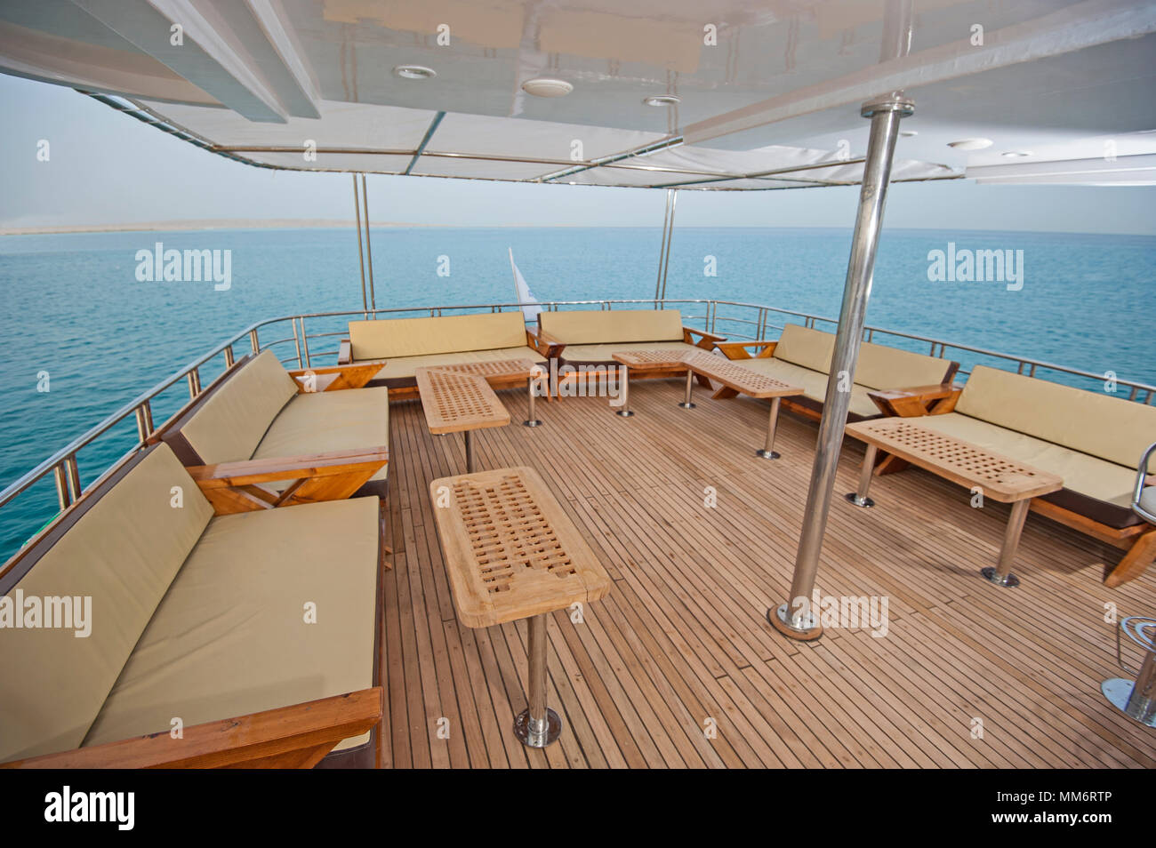 Pont arrière d'un grand yacht de luxe avec des chaises canapé table et fond sur la mer tropicale Banque D'Images