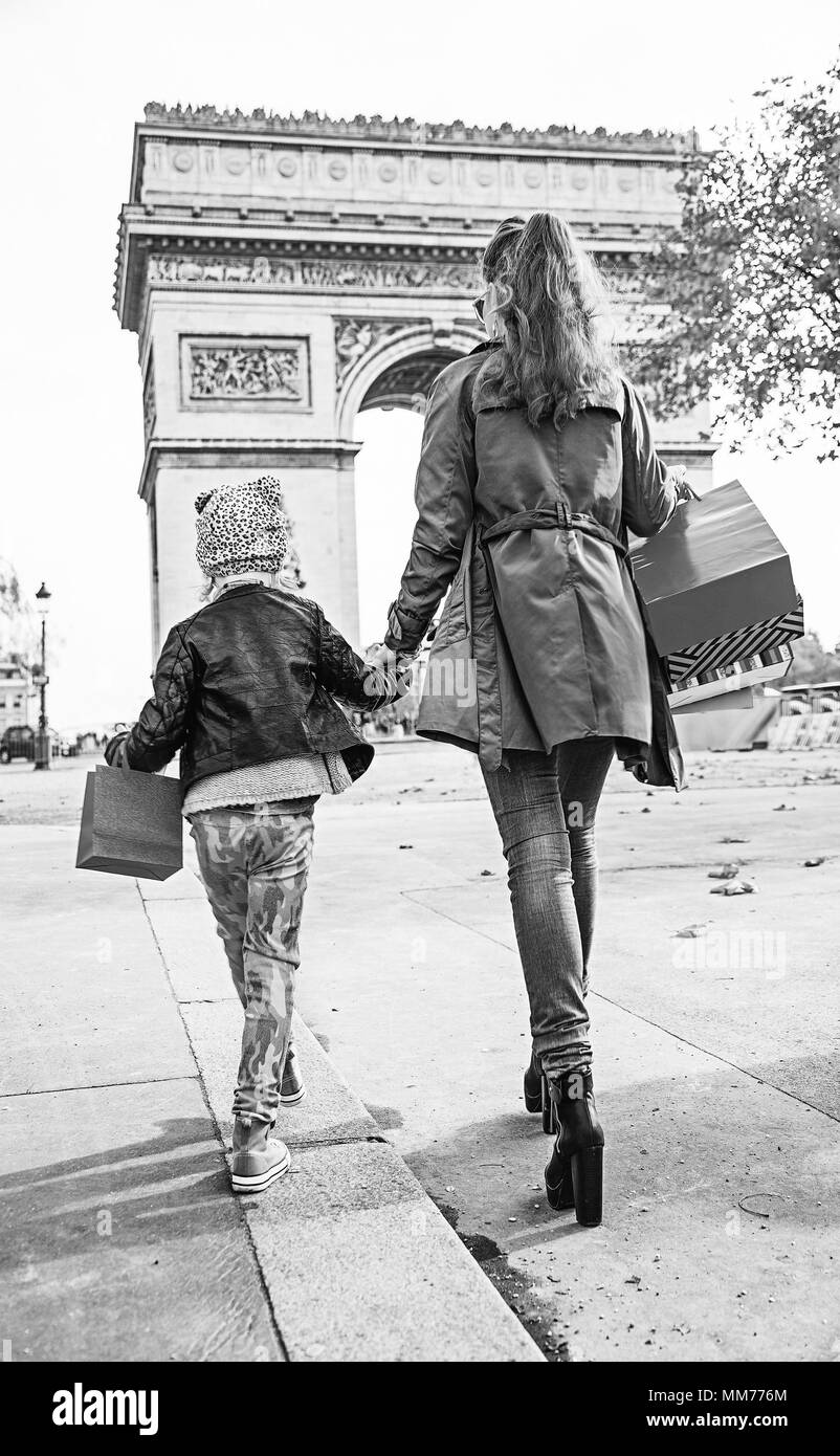 Automne élégante à Paris. Vus de derrière, portrait de jeune mère et l'enfant avec des sacs de shopping à Paris, France walking Banque D'Images