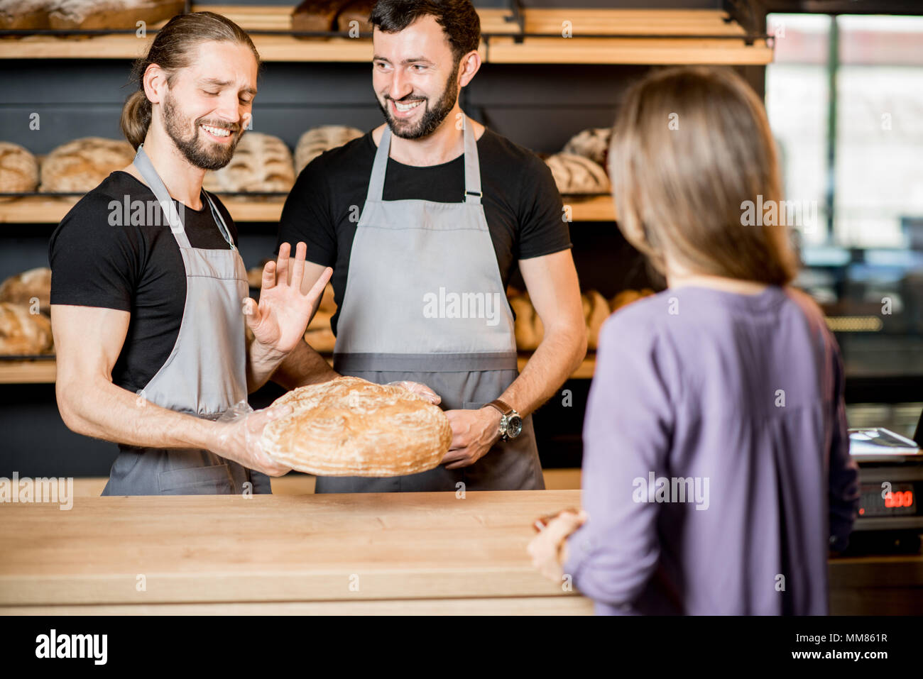 Femme acheter du pain dans la boulangerie avec l'homme ventes Banque D'Images