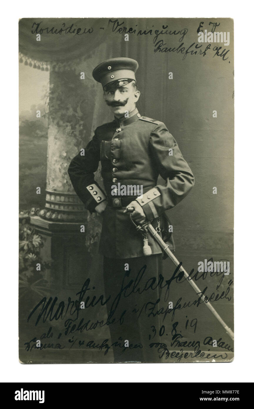 Old German photo de 1919 : un homme en uniforme avec une moustache noire et une épée à sa ceinture. L'acteur de théâtre dramatique. Autographe. Mise en scène militaire. Banque D'Images