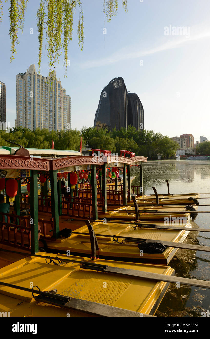Location de bateaux sur le lac du Parc de Chaoyang à Beijing, en Chine, avec les tours de Palm Springs et de résidence le Parc de Chaoyang Plaza par MAD architectes derrière Banque D'Images