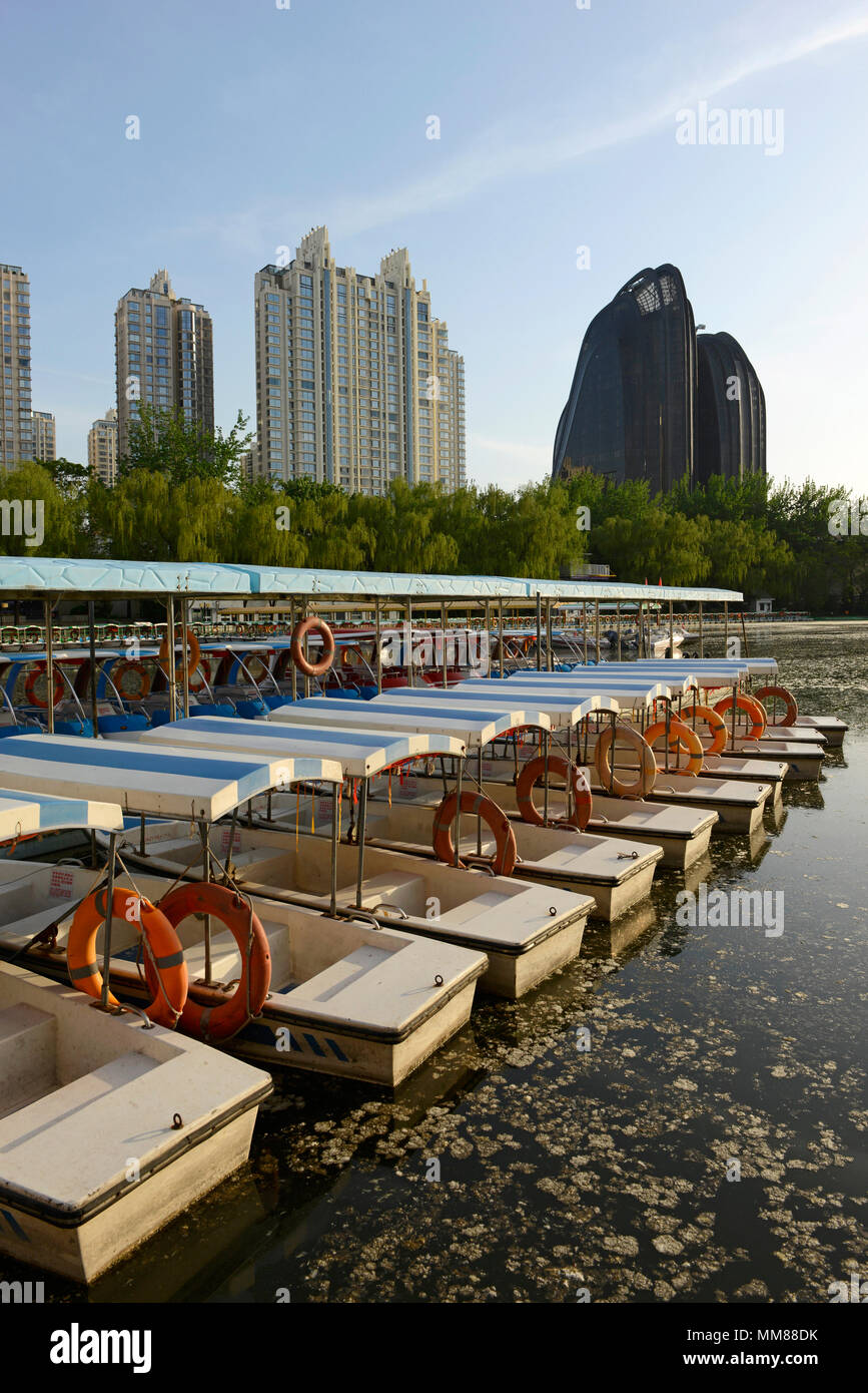 Location de bateaux sur le lac du Parc de Chaoyang à Beijing, en Chine, avec les tours de Palm Springs et de résidence le Parc de Chaoyang Plaza par MAD architectes derrière Banque D'Images