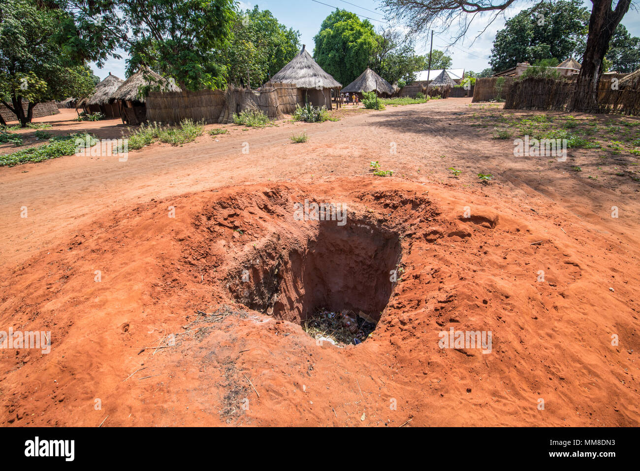 En regardant la fosse creusée dans le village qui est utilisé pour l'élimination des déchets, Mukuni Village, Zambie Banque D'Images