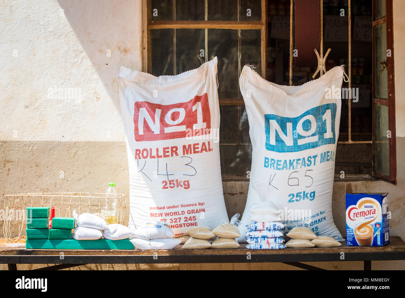 Deux gros sacs contenant des aliments non périssables s'asseoir sur le dessus de table avec d'autres aliments emballés, Mukuni Village, Zambie Banque D'Images
