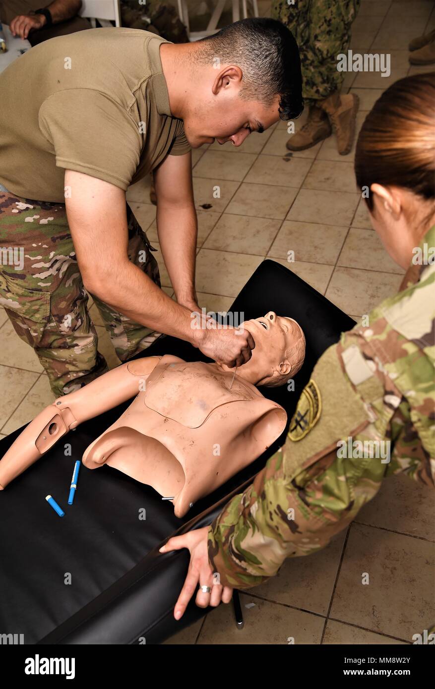 Le sergent de l'armée américaine, Crystal Velasquez, Combined Joint Task Force-Horn of Africa conseiller médical principal engagé et chargé de cours, les montres de l'armée américaine comme la CPS. Josue Mendez insère une aiguille cathéter pour relâcher la tension pneumothorax sur un modèle de pratique au cours d'un combat qui a eu lieu le cours sauveteur Camp Lemonnier, Djibouti, le 11 septembre 2017. La procédure est utilisée par les professionnels de la santé et lutter contre les sauveteurs pour atténuer la pression positive dans la cavité thoracique qui peut provoquer un effondrement de poumon. (U.S. Air National Guard photo de Tech. Le Sgt. Andria Allmond) Banque D'Images