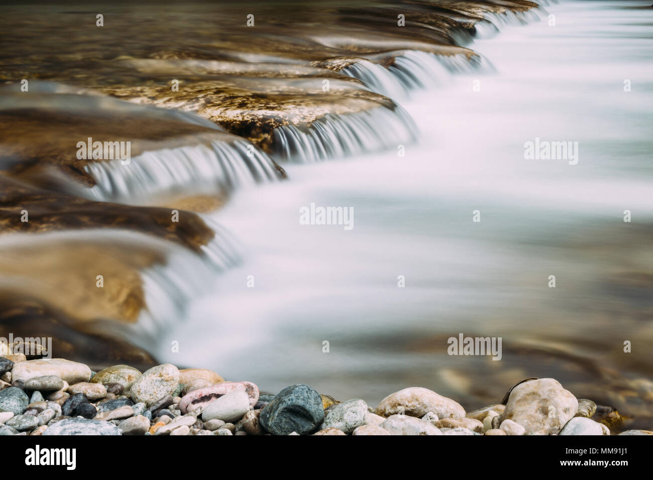 Petite cascade dans un riveer floue avec de l'eau Débit d'eau à partir de la longue exposition. Banque D'Images