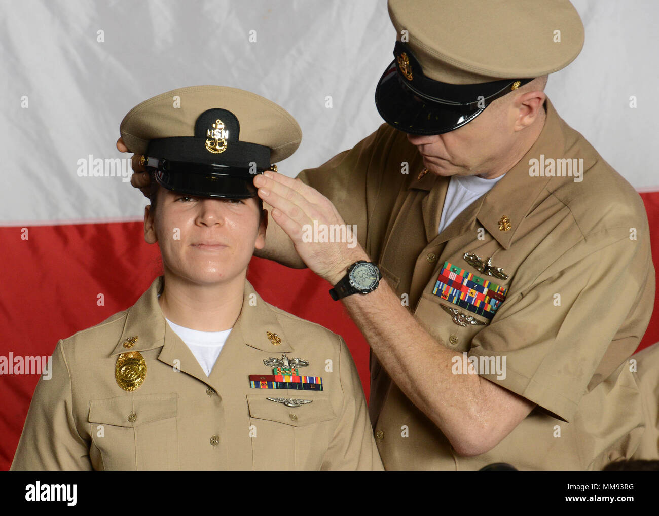 Le Golfe Arabique (sept. 15, 2017) La Marine américaine Chef Master-at-Arms Ashley Wilson, d'Oxford, Ohio, a son premier maître de couvrir enfilé par-électricien en chef John Gering pendant un premier maître de cérémonie l'épinglage à bord du porte-avions USS Nimitz (CVN 68), le 15 septembre 2017, dans le golfe Arabo-Persique. Nimitz est déployée dans la 5e flotte américaine zone d'opérations dans le cadre de l'opération inhérents résoudre. Alors que dans cette région, le navire et d'attaque mènent des opérations de sécurité maritime pour rassurer les alliés et les partenaires, de préserver la liberté de navigation, et de maintenir la libre circulation des com Banque D'Images