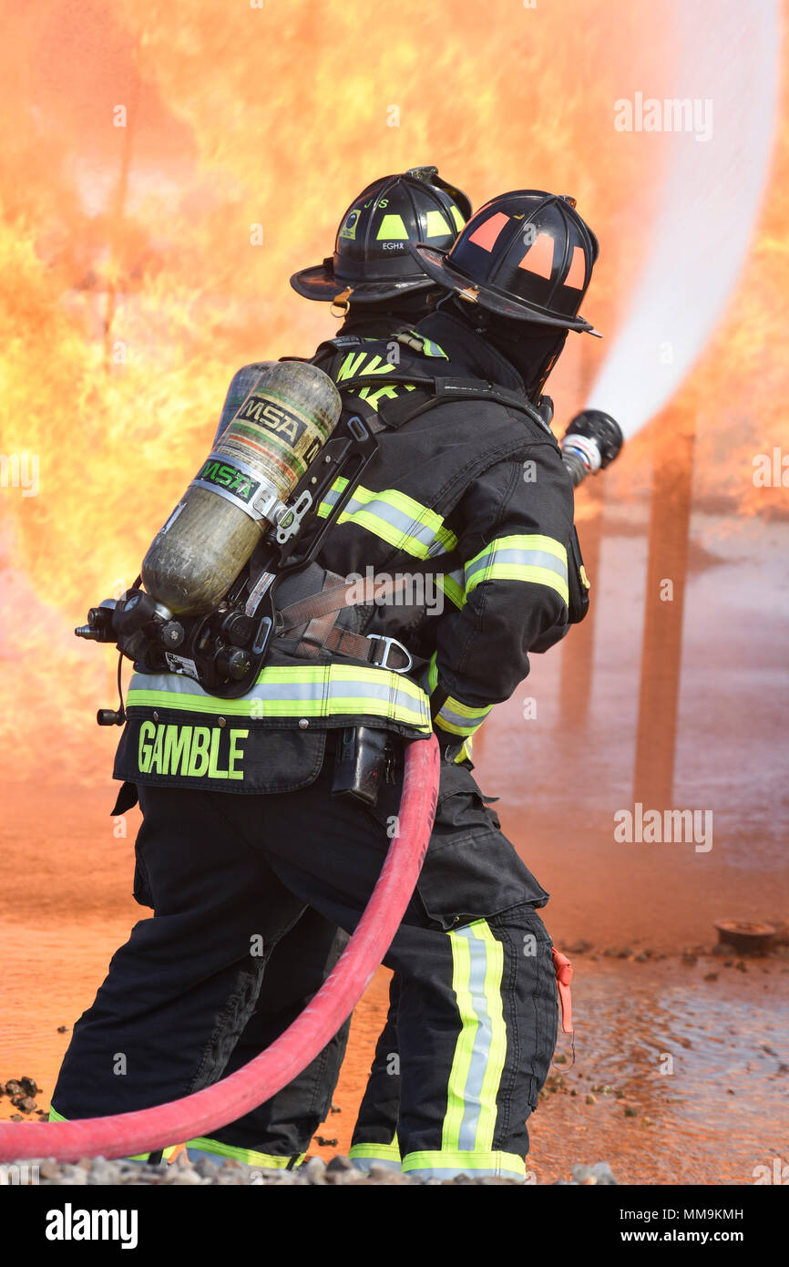 Deux états des équipes du 72e Escadron de génie civile, pompiers, travailler ensemble à l'approche de l'appareil de formation incendie de l'avion le 13 septembre 2017, Tinker Air Force Base, Texas. Les pompiers qui étaient en formation dans la recertification annuelle environnement réaliste. (U.S. Air Force photo/Greg L. Davis) Banque D'Images