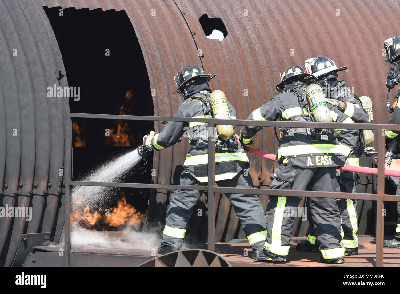 Les membres du 72e Escadron de génie civile, pompiers, travailler ensemble pour combattre un incendie près de la porte d'entrée de l'appareil de formation les incendies d'aéronefs, du 13 septembre 2017, Tinker Air Force Base, Texas. Les pompiers ont pris chacun tourne dans la porte afin de confirmer le bon fonctionnement technique de l'incendie pour la situation au cours de recertification annuelle de formation. (U.S. Air Force photo/Greg L. Davis) Banque D'Images