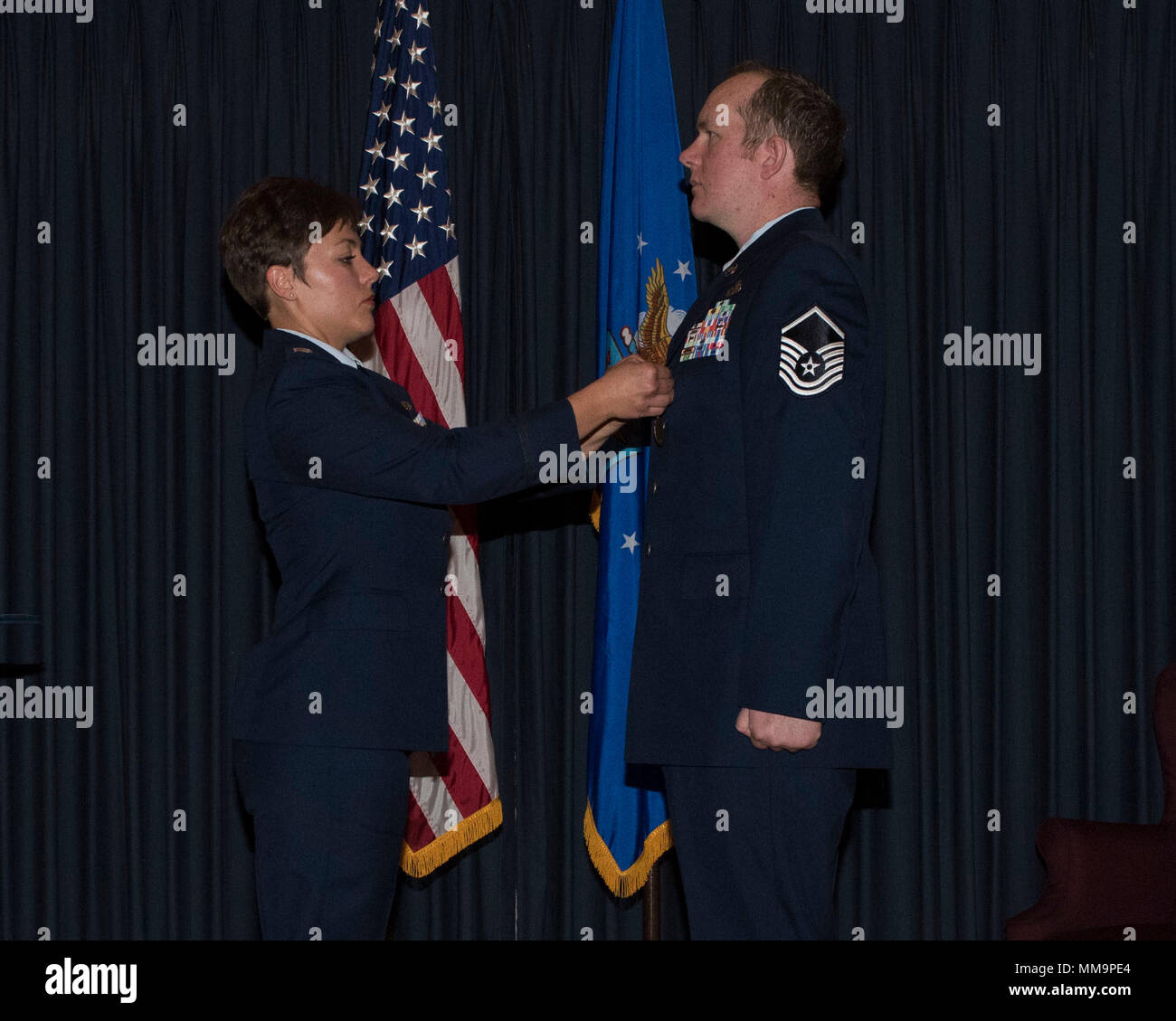 Le capitaine Anya Davis, agent officiel, axes Master Sgt. Daniel Hill's, 366e Escadre de chasse, Chef de section d'opérations de terminal, médaille de la retraite, le 15 septembre 2017, à Mountain Home Air Force Base, Texas. Hill a pris sa retraite après 14 années de service actif. (U.S. Air Force Photo par un membre de la 1re classe Malaisie Berry/ libéré) Banque D'Images
