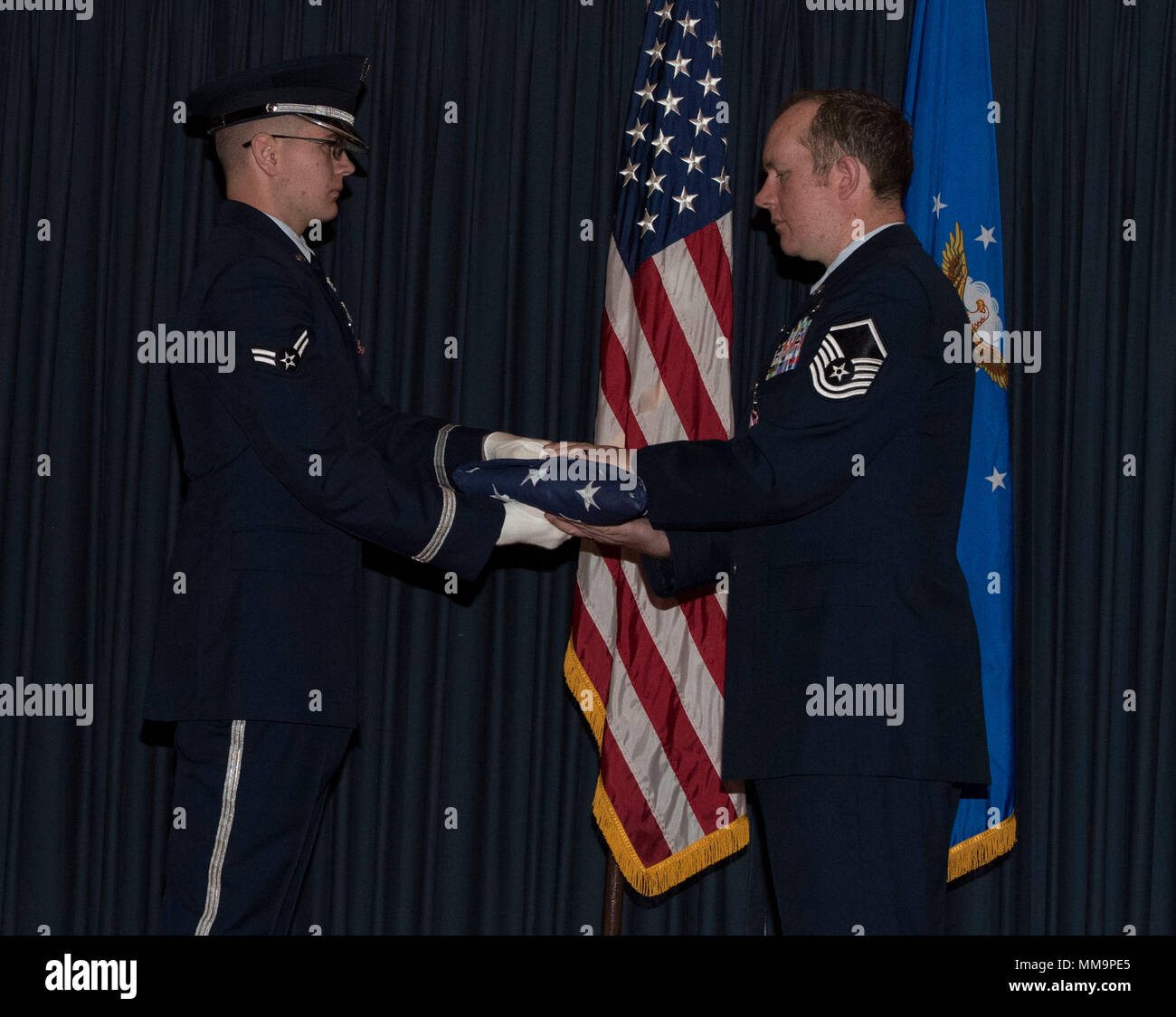 Le sergent-chef Daniel Hill, 366e Escadre de chasse, Chef de section d'opérations de terminal, accepte un drapeau plié à sa retraite, le 15 septembre 2017, à Mountain Home Air Force Base, Texas. Hill a pris sa retraite après 14 années de service actif. (U.S. Air Force Photo par un membre de la 1re classe Malaisie Berry/ libéré) Banque D'Images