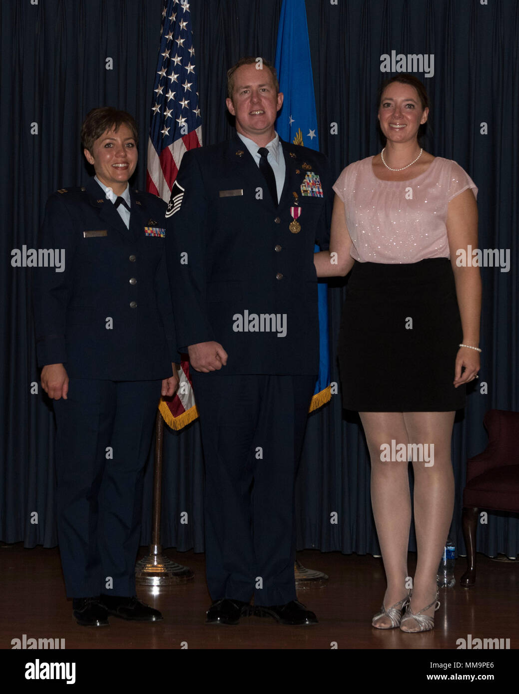 Le sergent-chef. Daniel Hill, 366e Escadre de chasse, Chef de section d'opérations de terminal, de sourires pour une photo avec sa femme, Lena Hill, et le capitaine Anya Davis, agent officiel, le 15 septembre 2017, à Mountain Home Air Force Base, Texas. Hill a pris sa retraite après 14 années de service actif. (U.S. Air Force Photo par un membre de la 1re classe Malaisie Berry/ libéré) Banque D'Images
