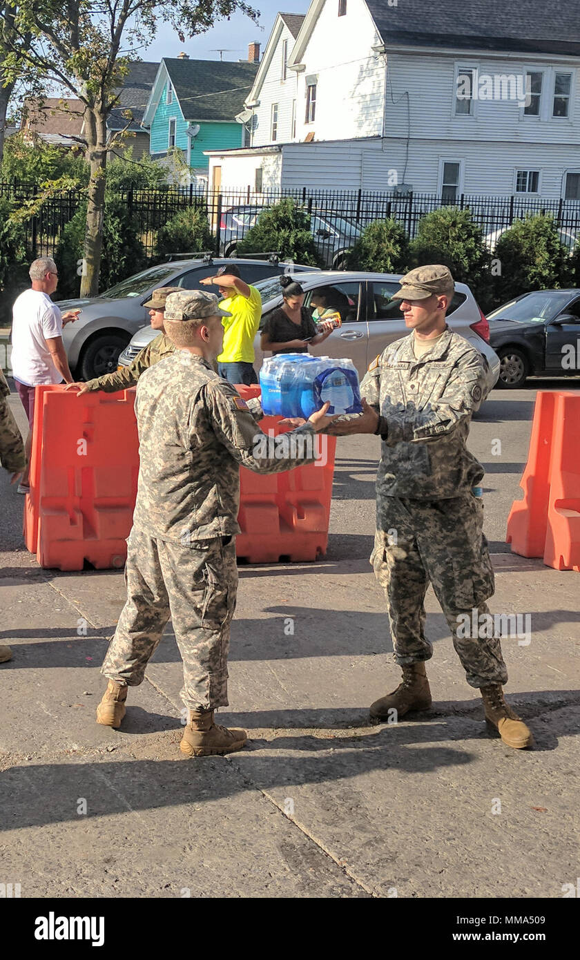 La CPS de l'armée. Kevin Dulinawka, centre, facilite la réussite fait don de cas de l'eau à une Garde Nationale de New York point de collecte de dons à l'Ohio Street Armory à Buffalo, N.Y., Dulinawka avec d'autres soldats du 27e Bataillon des troupes spéciales de la Brigade, a aidé à recueillir des dons pour Porto Rico et les Îles Vierges américaines dans le cadre de l'appui de New York pour les efforts de rétablissement après les ouragans Irma et Maria. La Garde Nationale de New York compte plus de 700 soldats et aviateurs, soutenir les efforts de rétablissement, à partir de l'avant des avions et des membres du personnel déployés pour soutenir 14 nouveaux centres de don Yo Banque D'Images