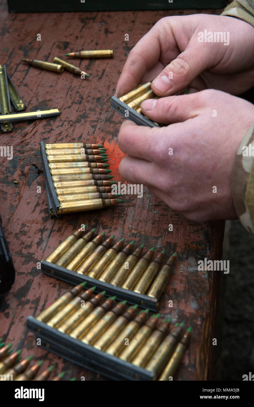 Un aviateur, affecté au 3e escadron des opérations d'appui aérien, les supports 5,56 mm balles ordinaires sur un clip décapant de tir réel au cours de soutien la formation at Joint Base Elmendorf-Richardson, Alaska, le 28 septembre 2017. Au cours de l'exercice d'entraînement de la 3e ASOS aviateurs ont perfectionné leur adresse au tir et a exercé divers postes de tir utilisant le pistolet M9 et M4 Carbine. (U.S. Air Force photo par Alejandro Peña) Banque D'Images