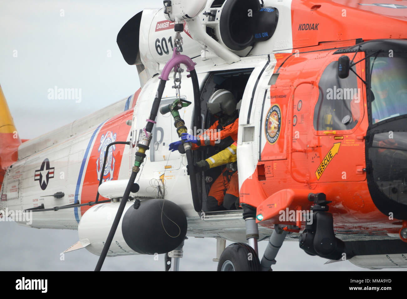 MH-60 Jayhawk est un hélicoptère de récupération bimoteur de moyenne portée exploité par la Garde côtière des États-Unis pour des missions de recherche et de sauvetage. L'image d'archive documente la formation au ravitaillement en vol dans l'Arctique en 2017, démontrant le déploiement des tuyaux de carburant pour étendre la portée opérationnelle pendant les opérations de sauvetage maritime. Banque D'Images