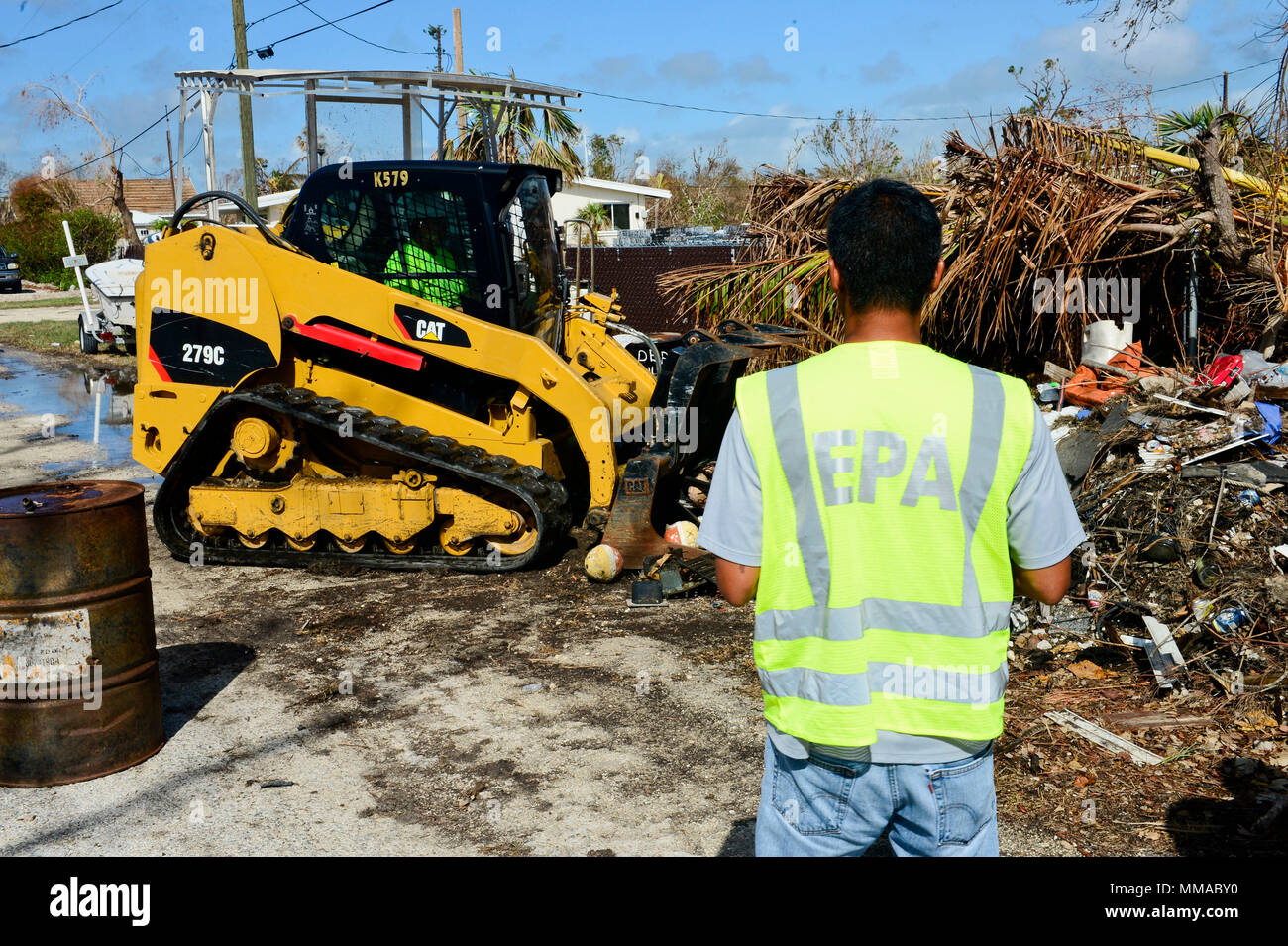 Subash Patel, un coordonnateur sur place avec l'Agence de protection de l'environnement, dirige l'élimination des barils et contenants de personnes déplacées par le cyclone Irma à Big Pine Key, en Floride, le 3 octobre 2017. Les équipes de terrain de l'EPA, dirigé par les coordonnateurs sur place, sont de faciliter les évaluations fondées sur des terres et des actions de réponse en coordination avec le commandement unifié de la fonction de soutien en cas d'urgence 10 en Floride. U.S. Coast Guard photo de Maître de 2e classe David Weydert. Banque D'Images