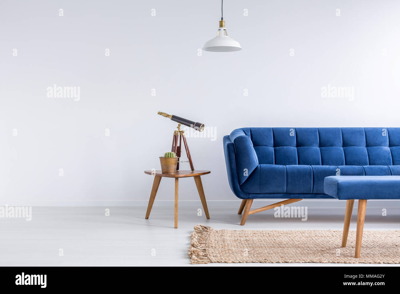 Appartement lumineux avec canapé bleu, banc, tapis, table et lampe Banque D'Images