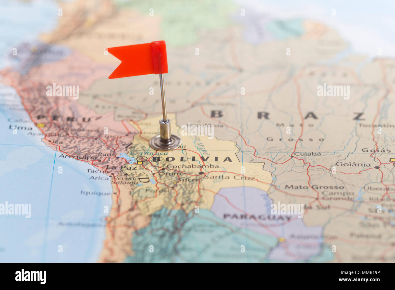 Petit drapeau rouge marquant le pays d'Amérique du Sud de la Bolivie sur une carte du monde. Banque D'Images