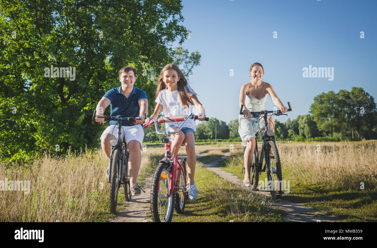 Image de ton mignon 10 ans girl riding bicycles avec les parents sur le terrain Banque D'Images