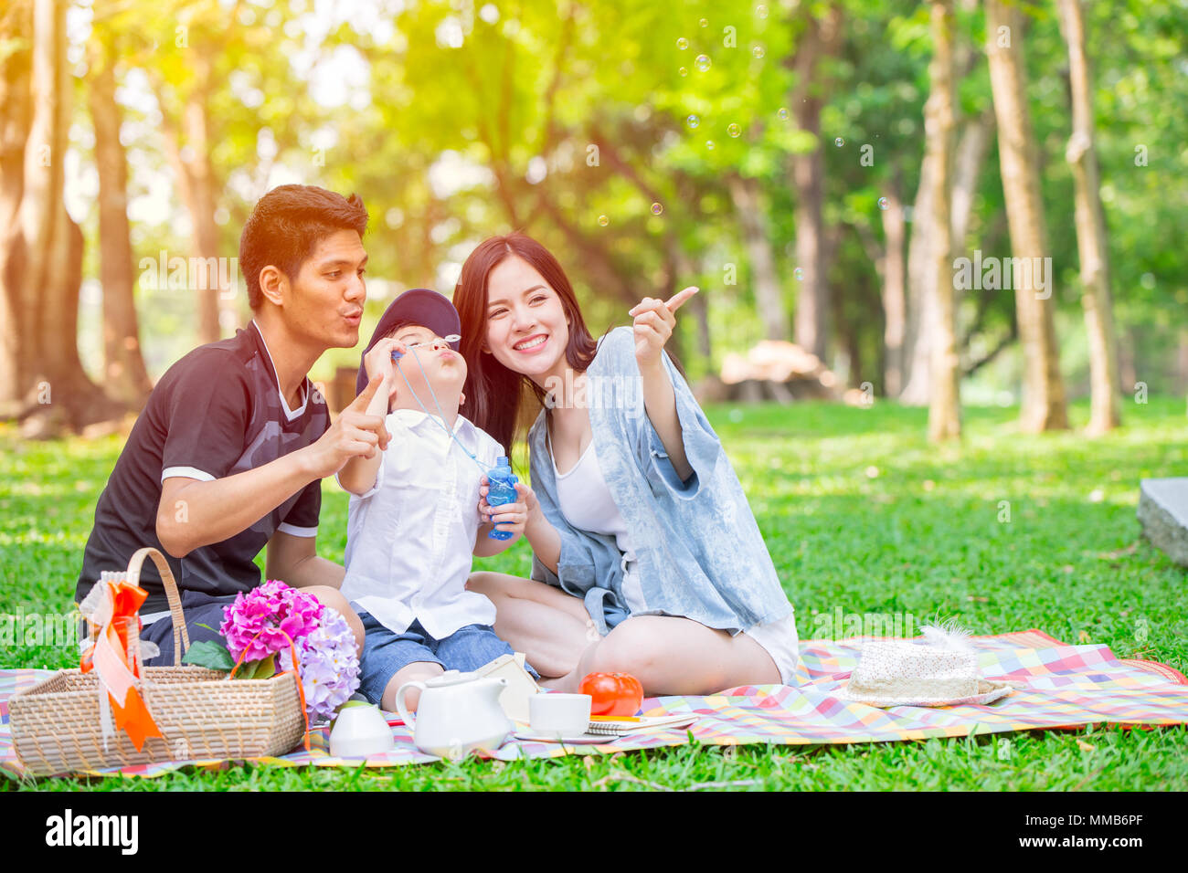Un enfant de la famille vendeuse heureux vacances moment pique-nique dans le parc. Jouer bubble. Banque D'Images