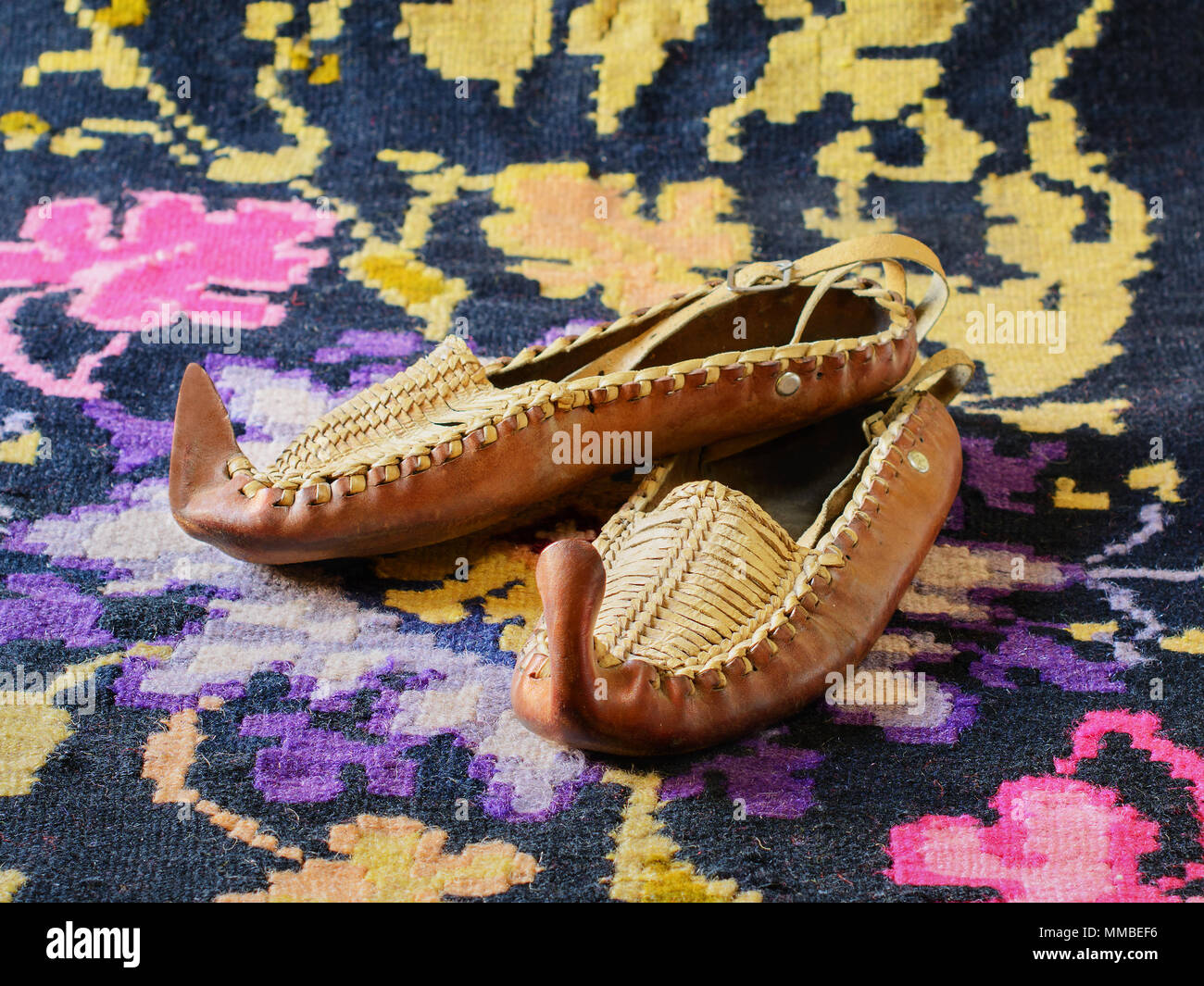 Opanci, cuir chaussures traditionnelles folkloriques, une partie de l'costume national serbe, sont situées sur un kilim, une télévision traditionnels fabriqués à la main-tissés Tapis de plancher. Banque D'Images