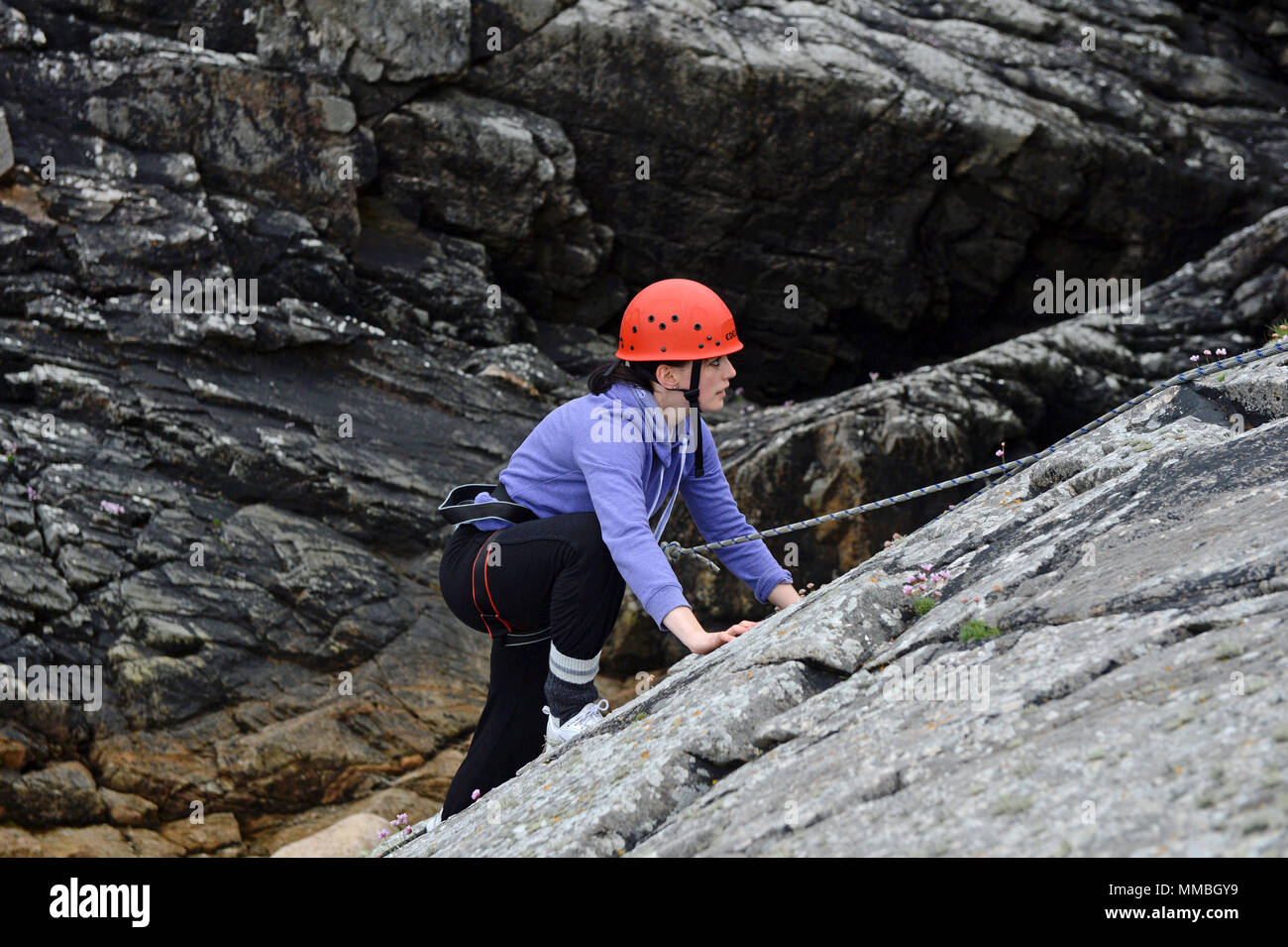 Escalade club d'escalade et la descente en rappel sur les falaises à côté de la mer. Une variété de participants jeunes et vieux Banque D'Images