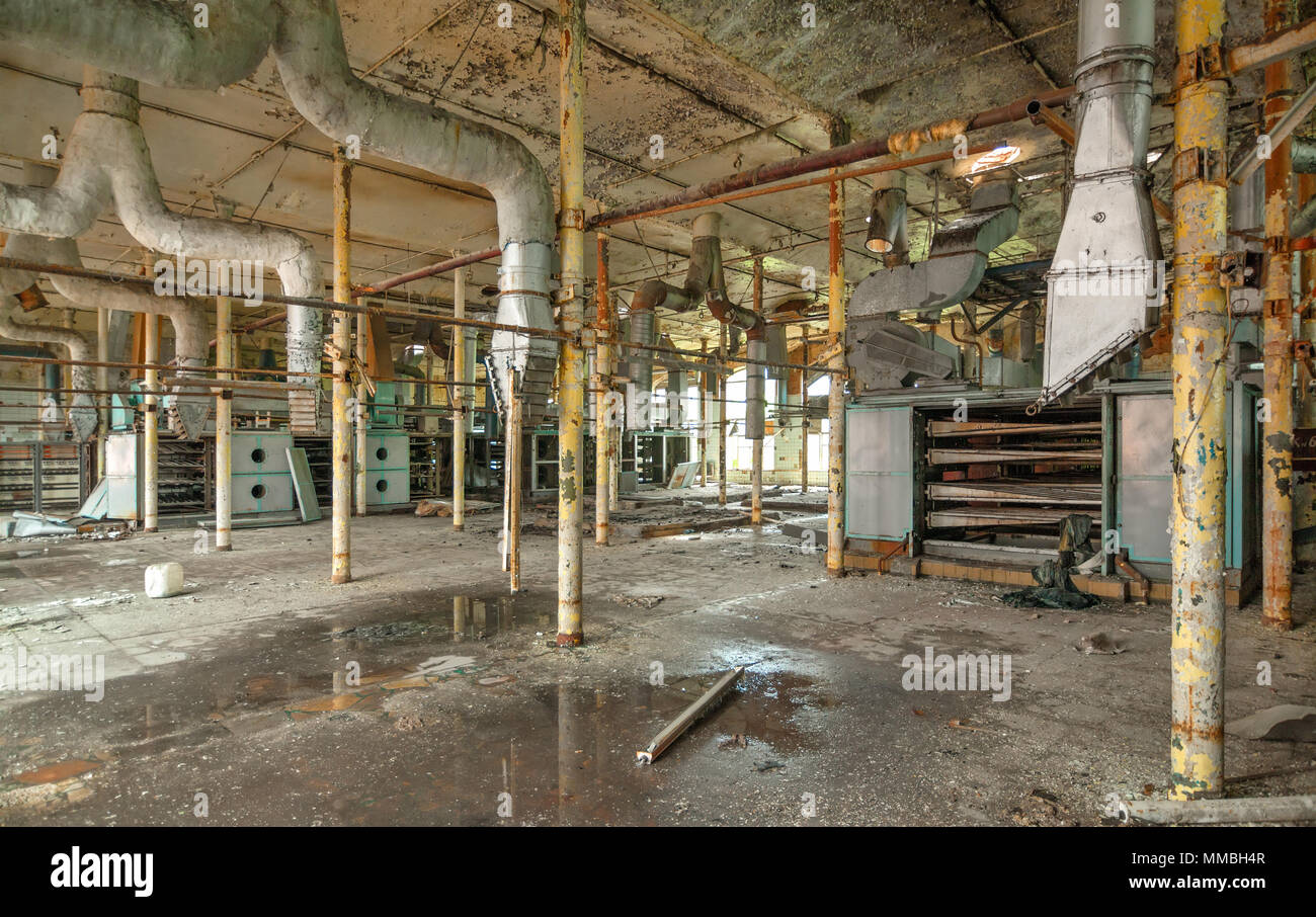 Salle de production détruit d'une ancienne usine textile abandonnée avec reste de l'équipement brisé Banque D'Images