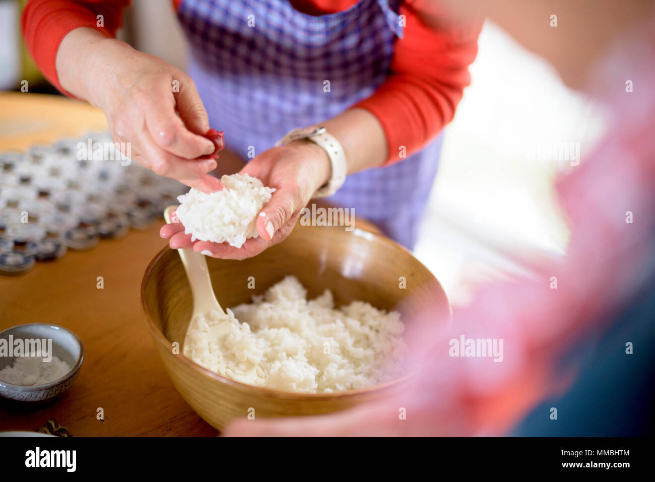 Close up of woman standing à une table dans une cuisine, faire des sushis. Banque D'Images