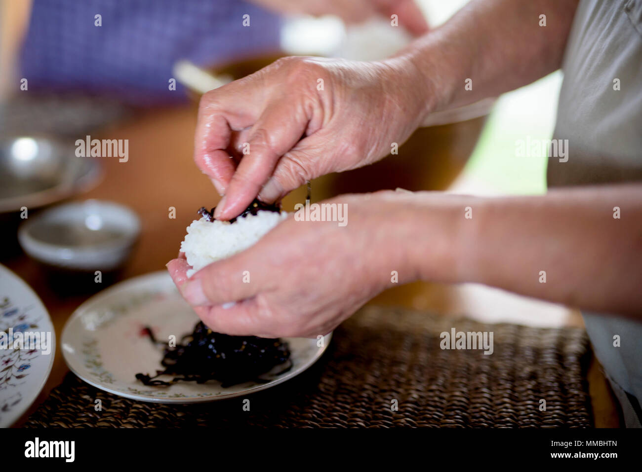 Close up of woman standing à une table dans une cuisine, faire des sushis. Banque D'Images
