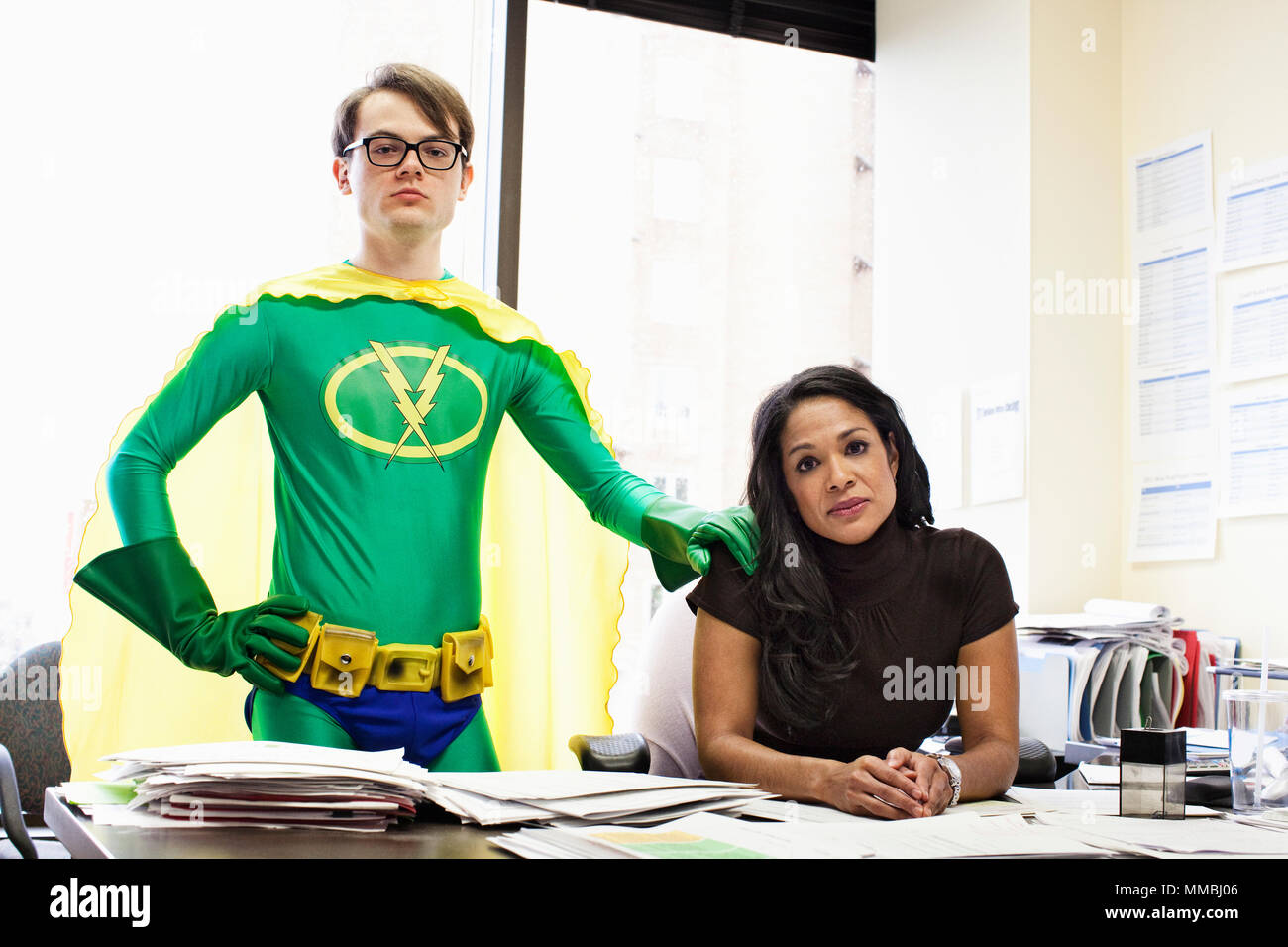 Une femme d'affaires noirs à son bureau avec son bureau caucasien conseiller de super héros. Banque D'Images