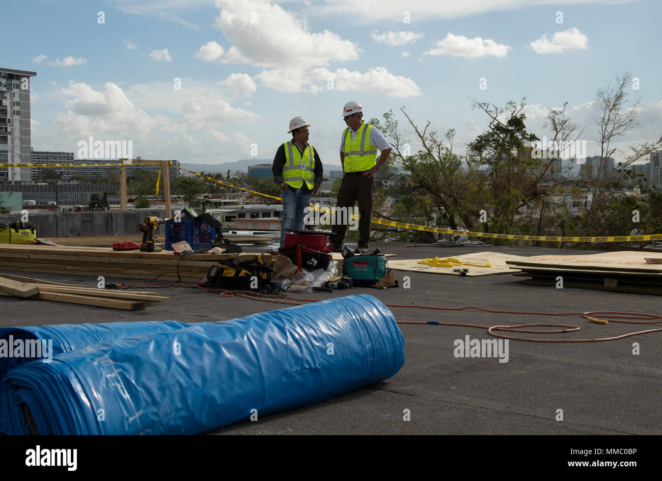 Les entrepreneurs travaillant pour les Corps des ingénieurs à Puerto Rico Installez le premier pavillon bleu sur la Multy installations médicales à San Juan. Avoir le toit sera protégé à l'hôpital d'ouvrir d'autres lits de patients/chambres qui étaient auparavant inaccessibles à cause de la toiture endommagée. De gauche à droite LCDO Moises Rivera Ramos, de la conformité et de l'action officielle Mike Rodgers du quartier St Louis. Banque D'Images