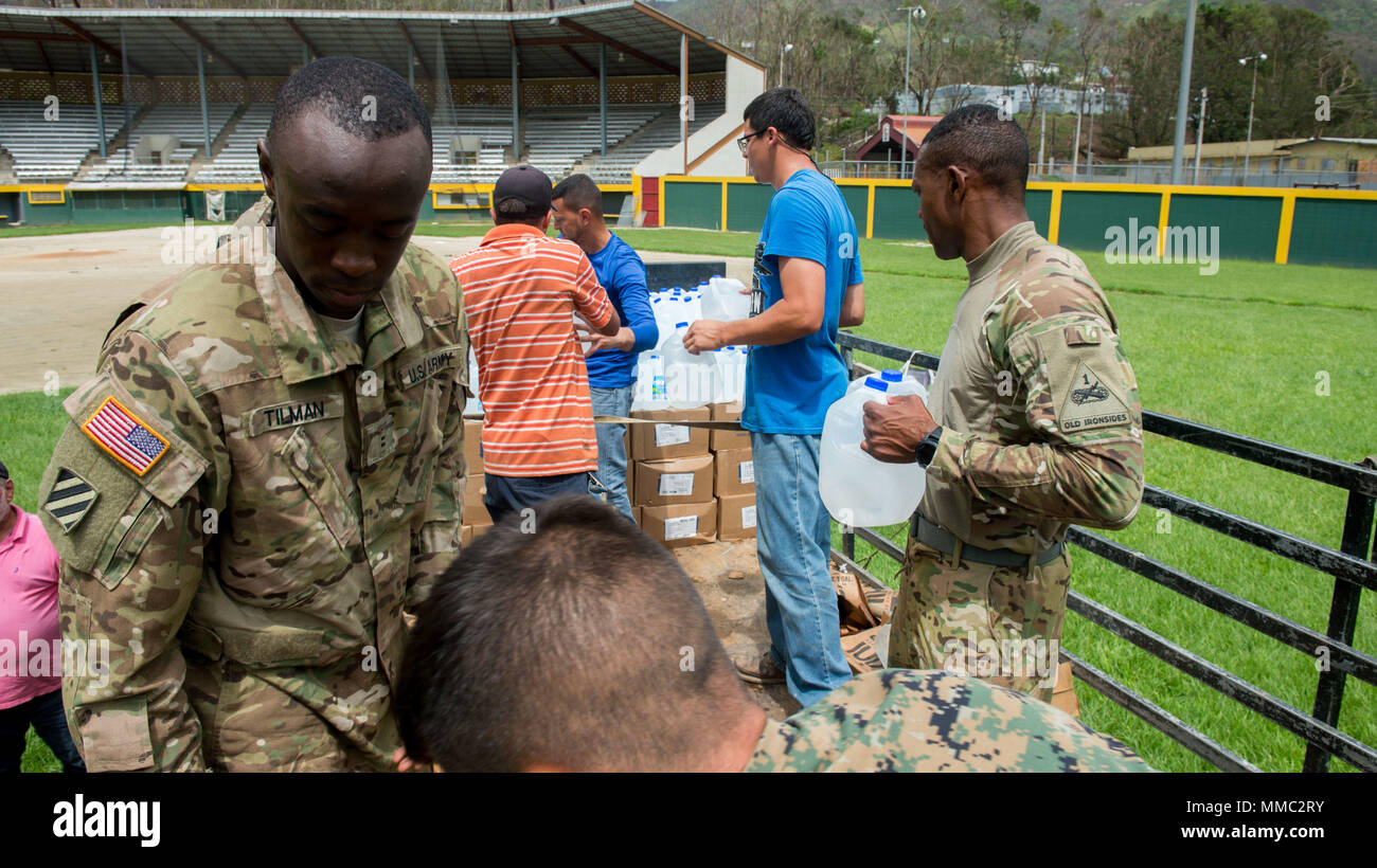 171009-N-KH675-003 JAYUYA, Puerto Rico (oct. 9, 2017) - 171009-N-KH675-004 JAYUYA, Puerto Rico (oct. 9, 2017) - Des soldats de la réserve de l'Armée américaine affecté à la 1ère Commande de soutien de mission, marines affectés à l'escadron 162 à rotors basculants Support Marine, et Portoricains des bénévoles de la décharger de la nourriture et de l'eau à partir d'un Black Hawk UH-60M sur un camion destiné à la distribution à l'Ouragan Maria victimes. Le ministère de la Défense soutient l'Agence fédérale de gestion des urgences, le principal organisme fédéral, en aidant les personnes touchées par l'Ouragan Maria afin de minimiser la souffrance et comme un élément de l'ensemble de Wh Banque D'Images