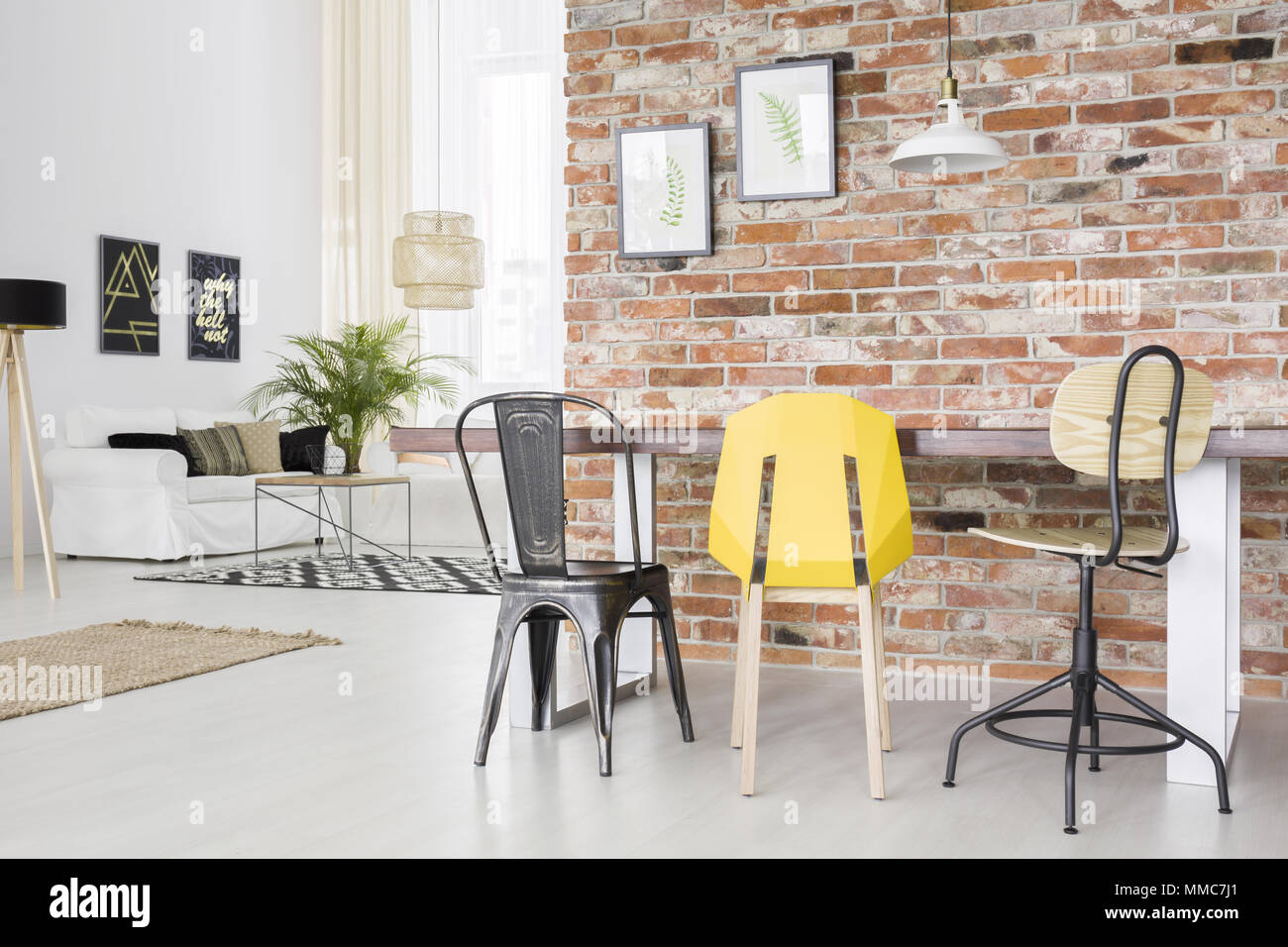 Appartement moderne avec mur de brique, table à manger, chaise et canapé Banque D'Images