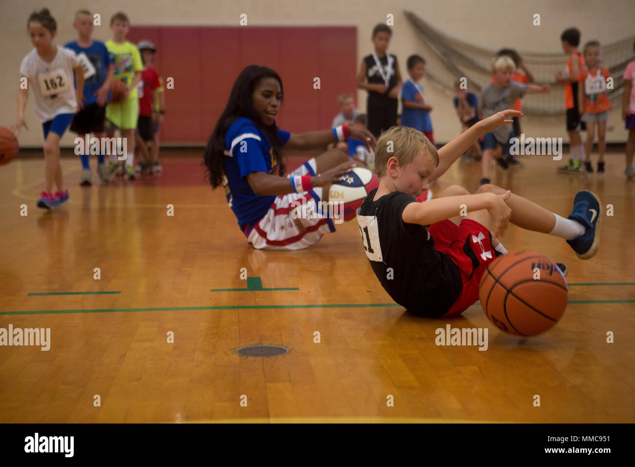 Harlem Globetrotter Fatima "TNT" Lister ne déplacer un dribble avec un  enfant à la salle de sport pendant un bon Semper youth basketball clinic  sur base du Corps des Marines, Hawaii, le