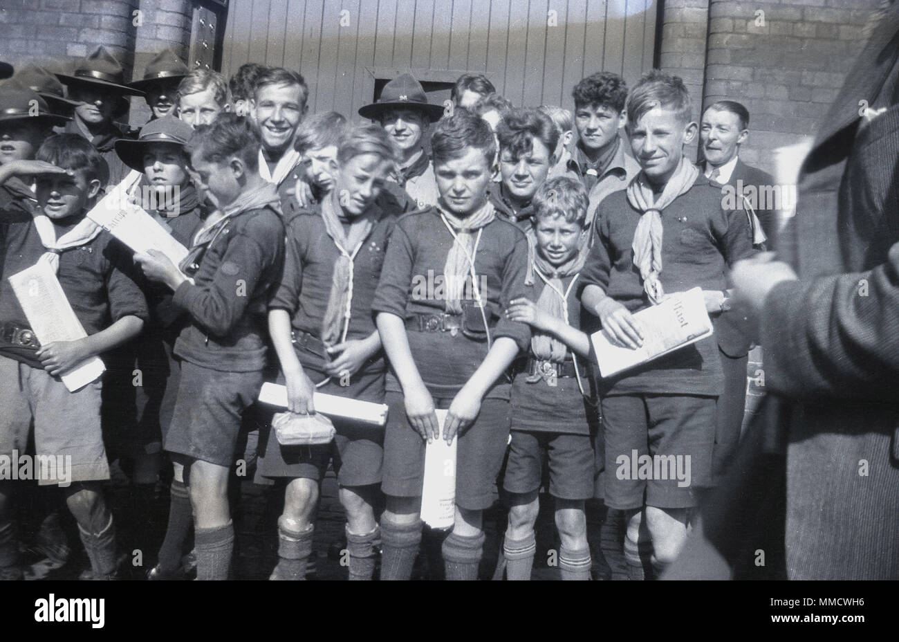 années 1930, un grand groupe de scouts enthousiastes, avec des certificats, rassemblés à l'extérieur. De différents âges, les plus âgés portant des chapeaux, les scouts viennent de rentrer en masse d'un voyage à l'étranger en Irlande. Banque D'Images