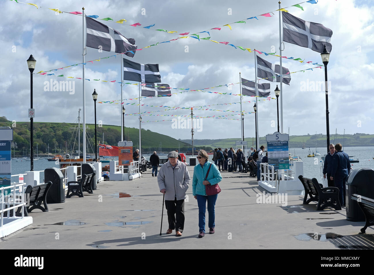 Personnes marchant sur un quai avec drapeaux de Cornouailles Banque D'Images