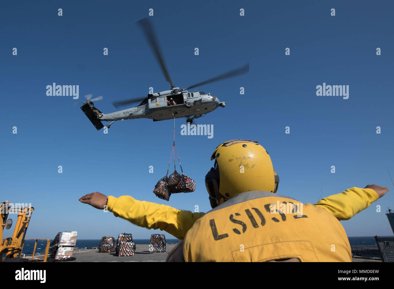 171004-N-OW019-131 U.S 5ÈME ZONE DES OPÉRATIONS DE LA FLOTTE (oct. 4, 2017) Maître de Manœuvre 3e classe David Watson, originaire de Birmingham, Alabama, attribué à service pont à bord du navire de débarquement quai amphibie USS Pearl Harbor (LSD 52), diriger les opérations de vol tout en étant soutenu par Marine Cpl. Ryan Carr pendant un ravitaillement vertical (VERTREP). Pearl Harbor est une partie de l'Amérique du groupe amphibie (ARG) et, avec l'entrepris 15e Marine Expeditionary Unit (MEU), est déployé à l'appui d'opérations de sécurité maritime et les efforts de coopération en matière de sécurité dans le théâtre dans la zone 5e Flotte des États-Unis Banque D'Images