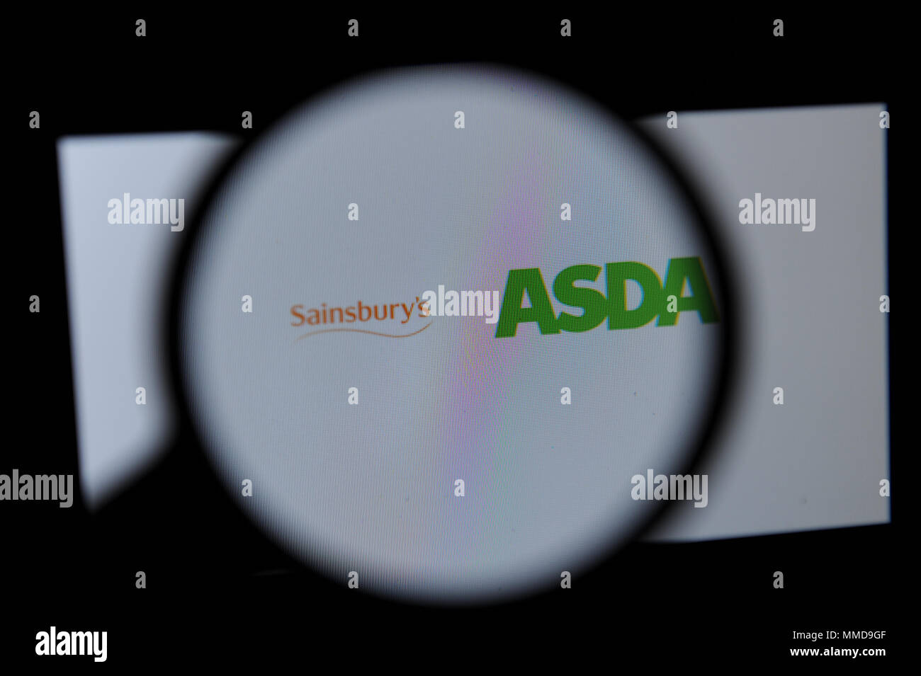 Le Sainsbury et Asda logos vu à travers une loupe Banque D'Images