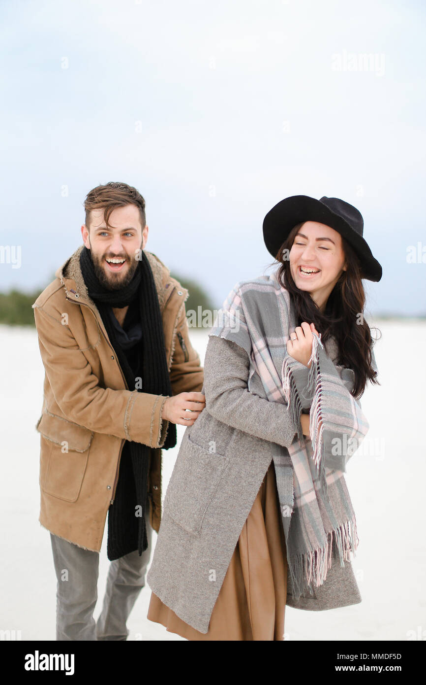 Femme et homme portant des manteaux et des écharpes en arrière-plan permanent de la neige d'hiver. Banque D'Images