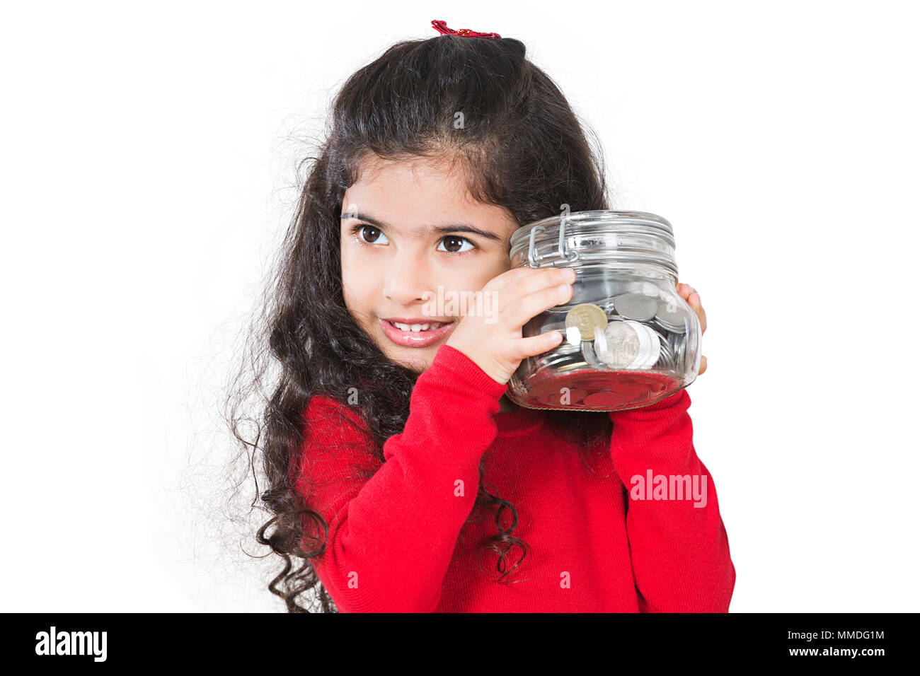 Un enfant Girl Holding Jar of Coins Tirelire d'économiser de l'argent Banque D'Images