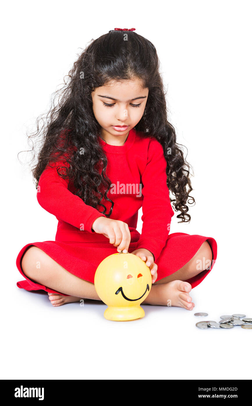 Une petite fille assise étage Pièce Piggy-Bank Mettre à économiser de l'argent Banque D'Images