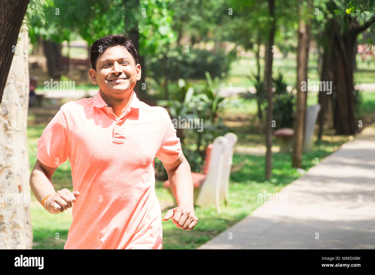 Un homme conscient d'exécution exercice matinal en jogging Work-Out Parc Banque D'Images