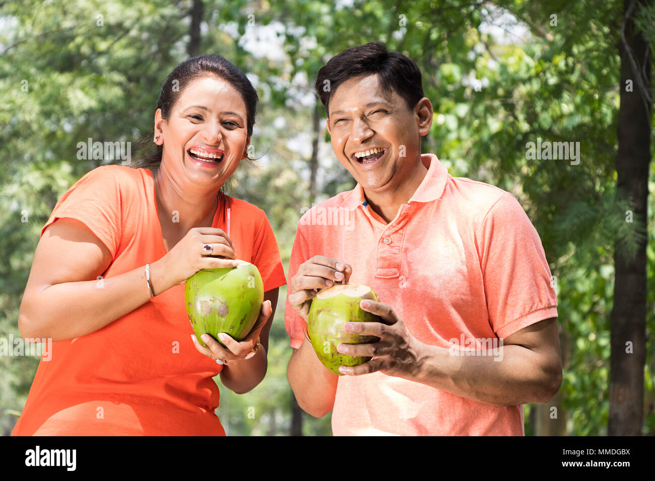 Deux heureux couple Park de boire le lait de coco Fun bénéficiant d In-Garden Banque D'Images